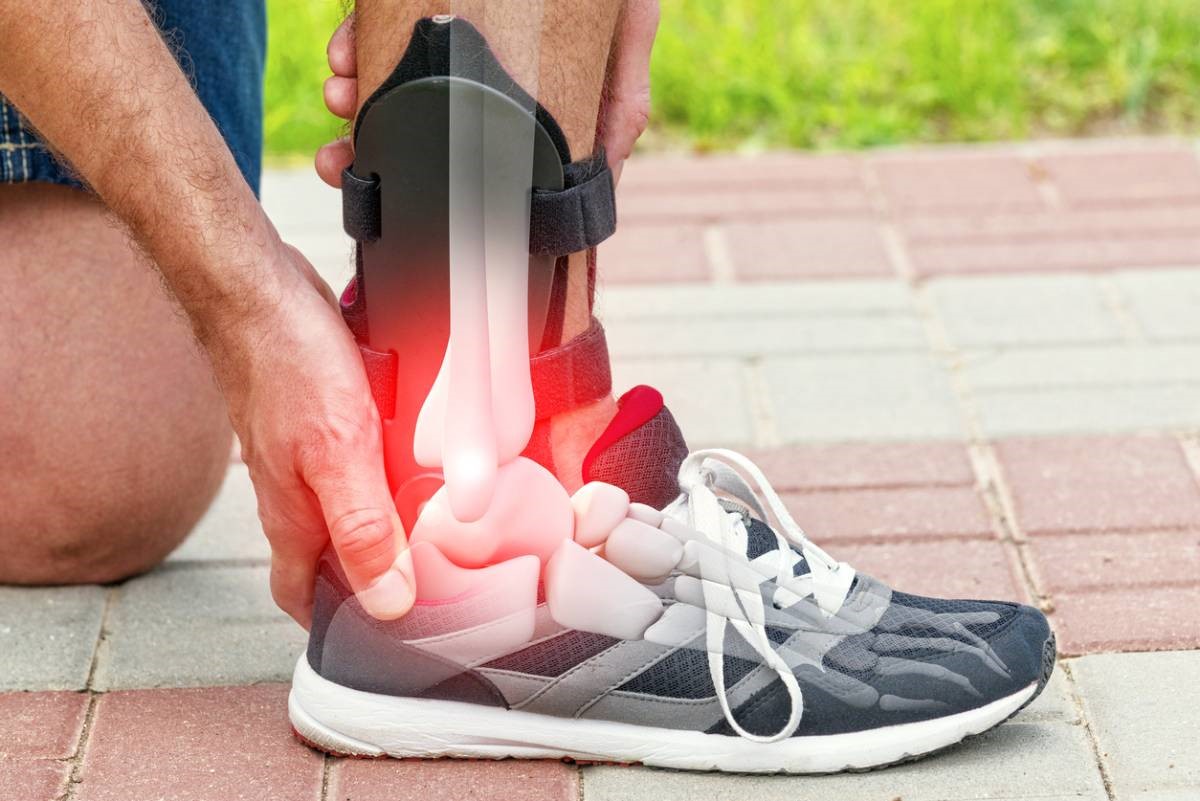 X-Ray cutaway of foot and ankle, showing bones, with red light emanating from ankle to show pain